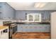 Traditional kitchen features blue cabinets, black countertops and stainless steel appliances at 2609 Pleasant Hill Liberty Rd, Liberty, NC 27298