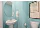 Light-blue powder room with an oval mirror and pedestal sink at 261 Holton St, Smithfield, NC 27577