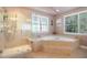 A full bathroom with a tiled shower, corner tub, and bright natural light from multiple windows at 4009 Brittabby Ct, Raleigh, NC 27606