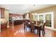 View of open dining room and kitchen area with hardwood floors, dark wood cabinets, and stainless steel appliances at 4009 Brittabby Ct, Raleigh, NC 27606