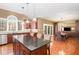 Open concept kitchen with a large island, dark wood cabinets, and granite countertops at 4009 Brittabby Ct, Raleigh, NC 27606