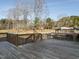 Backyard view with spacious deck, wooden fence, mature trees, and animal enclosures at 4063 Nc-39, Selma, NC 27576