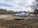 The home's backyard features a small above-ground pool, white vinyl fencing, and another structure at 4063 Nc-39, Selma, NC 27576