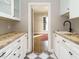 Convenient butler pantry with shelving, sink, white cabinets, and view to dining room at 4063 Nc-39, Selma, NC 27576