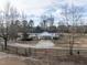 A white farmhouse with a connecting garage and long driveway lined with mature trees and fencing at 4063 Nc-39, Selma, NC 27576