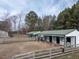 Horse barn facility with fenced paddocks and surrounding foliage at 4063 Nc-39, Selma, NC 27576