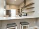 Bright kitchen features bar seating, stainless steel appliances, and open shelving at 4063 Nc-39, Selma, NC 27576