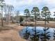 A scenic pond on the property features mature trees and a small dock for peaceful enjoyment at 4063 Nc-39, Selma, NC 27576