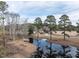 A scenic pond on the property features mature trees and a small dock for peaceful enjoyment at 4063 Nc-39, Selma, NC 27576