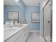 Elegant bathroom featuring double vanity, quartz countertops, blue accent wall, and tiled walk-in shower at 409 Grading Stick Ct, Angier, NC 27501