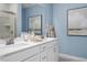 Elegant bathroom featuring double vanity, quartz countertops, blue accent wall, and tiled walk-in shower at 409 Grading Stick Ct, Angier, NC 27501