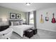 Comfortable bedroom with a cozy bed, decorative lamps, guitars, and a window with natural light at 409 Grading Stick Ct, Angier, NC 27501