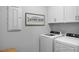 Modern laundry room with front load washer and dryer, decorated with framed laundry room sign at 409 Grading Stick Ct, Angier, NC 27501