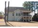Rear view of the home features a porch, windows, and staircase, with a lovely yard at 4305 Albino Deer Way, Wake Forest, NC 27587