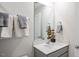 Bright bathroom features a vanity with a white countertop and sink, mirror, and a towel rack with gray towels at 452 Belgian Red Way, Wake Forest, NC 27587