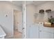 Bright laundry room features a white washer and dryer, with towels on wire shelving at 452 Belgian Red Way, Wake Forest, NC 27587