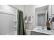 Clean bathroom features a shower with green curtain and a white sink, toilet, and wall mounted towel racks at 461 Belgian Red Way, Wake Forest, NC 27587