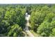 Aerial view of modern home surrounded by lush green forest and a private driveway at 4908 Birchleaf Dr, Raleigh, NC 27606