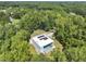 Modern home surrounded by lush greenery and topped with solar panels, adjacent to in-ground pool at 4908 Birchleaf Dr, Raleigh, NC 27606