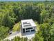 Aerial view of modern home featuring a rooftop solar panel system and lush green surroundings at 4908 Birchleaf Dr, Raleigh, NC 27606