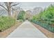 Long, straight driveway with trees on either side leading to gated entrance at 4908 Birchleaf Dr, Raleigh, NC 27606