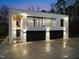 Stunning contemporary home with balcony and modern garage doors under a twilight sky at 4908 Birchleaf Dr, Raleigh, NC 27606