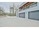 A driveway leads to a contemporary home with a balcony and garage doors, framed by trees in the background at 4908 Birchleaf Dr, Raleigh, NC 27606