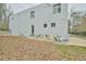 Side exterior of modern home with white walls, dark windows, and foliage at 4908 Birchleaf Dr, Raleigh, NC 27606