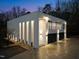 Elegant contemporary home illuminated at dusk, featuring a striking balcony and modern garage doors at 4908 Birchleaf Dr, Raleigh, NC 27606