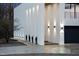 Contemporary home's unique design features columns, exterior lighting, and a driveway, set against a natural backdrop at 4908 Birchleaf Dr, Raleigh, NC 27606