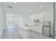 Bright, modern kitchen features white cabinetry, stainless steel appliances, and an island with countertop seating at 4908 Birchleaf Dr, Raleigh, NC 27606