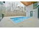 A modern pool with a tanning ledge is surrounded by a spacious concrete deck and a backyard at 4908 Birchleaf Dr, Raleigh, NC 27606