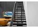 Modern black staircase adjacent to living space with a wall-mounted TV and comfortable leather sofa at 4908 Birchleaf Dr, Raleigh, NC 27606