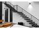 Contemporary staircase features black metal railings and open steps, with a partial view of the living area at 4908 Birchleaf Dr, Raleigh, NC 27606