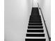 Modern staircase with black steps, white risers, and minimalist railing at 4908 Birchleaf Dr, Raleigh, NC 27606