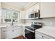 Bright kitchen features white cabinets, stainless appliances, and a window with a view at 5017 Pine Cone Dr, Durham, NC 27707