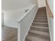 Carpeted staircase leads to the second floor with landing and wooden handrail at 556 Winding Creek Dr Dr, Lillington, NC 27546