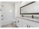 Bathroom features a double vanity with granite top, framed mirror, and tub with shower at 605 Lee St, Burlington, NC 27215
