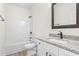 Bathroom features modern vanity with granite top, framed mirror, and tub with shower at 605 Lee St, Burlington, NC 27215