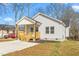 Charming single-story home featuring light gray siding, a welcoming front porch and manicured landscaping at 605 Lee St, Burlington, NC 27215