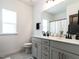 Bathroom featuring gray cabinets, double sinks, black accents, and a walk-in shower with a white curtain at 696 The Parks Dr, Pittsboro, NC 27312