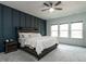 Bedroom with a wood accent wall, ceiling fan, and three windows offering natural light at 696 The Parks Dr, Pittsboro, NC 27312