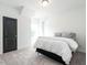 Bright bedroom featuring a black door, a gray carpet, and a bed with white bedding and gray pillows at 696 The Parks Dr, Pittsboro, NC 27312