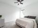 Bedroom with white walls, gray carpet, a white bed, a modern fan, and a small window at 696 The Parks Dr, Pittsboro, NC 27312