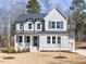 Charming two-story home with a covered front porch and a well-manicured lawn, showcasing its appealing facade at 696 The Parks Dr, Pittsboro, NC 27312