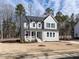 Charming two-story gray home with a covered porch, white columns, and beautifully landscaped front yard at 696 The Parks Dr, Pittsboro, NC 27312