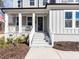 Inviting front entrance featuring a gray door, white brick stairs, and a charming covered porch at 696 The Parks Dr, Pittsboro, NC 27312