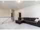 Second story hallway featuring a brown leather sectional couch and white wooden bannister on the staircase at 696 The Parks Dr, Pittsboro, NC 27312