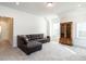 Bright living room with a brown leather sectional couch near the gun cabinet with lots of natural light at 696 The Parks Dr, Pittsboro, NC 27312
