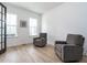 Office featuring two gray reclining chairs, ample natural light, and wood-look flooring at 696 The Parks Dr, Pittsboro, NC 27312
